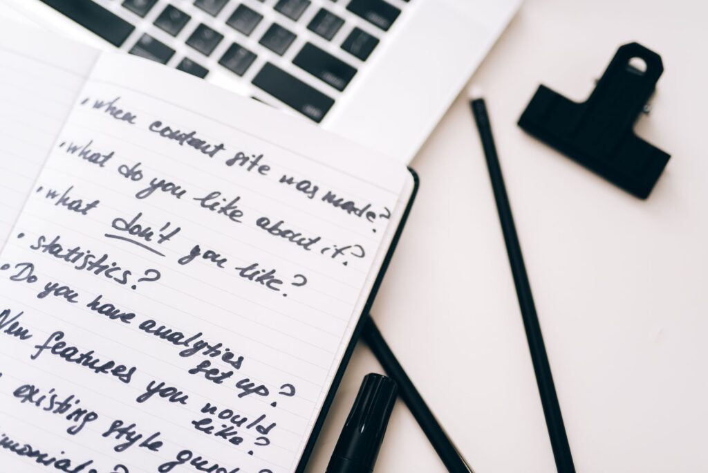 Planning content in a notebook beside a laptop